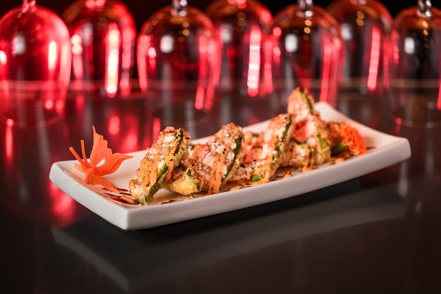 Sushi roll plated on white dish with red ambient lighting, commercial food photography Dallas, Texas