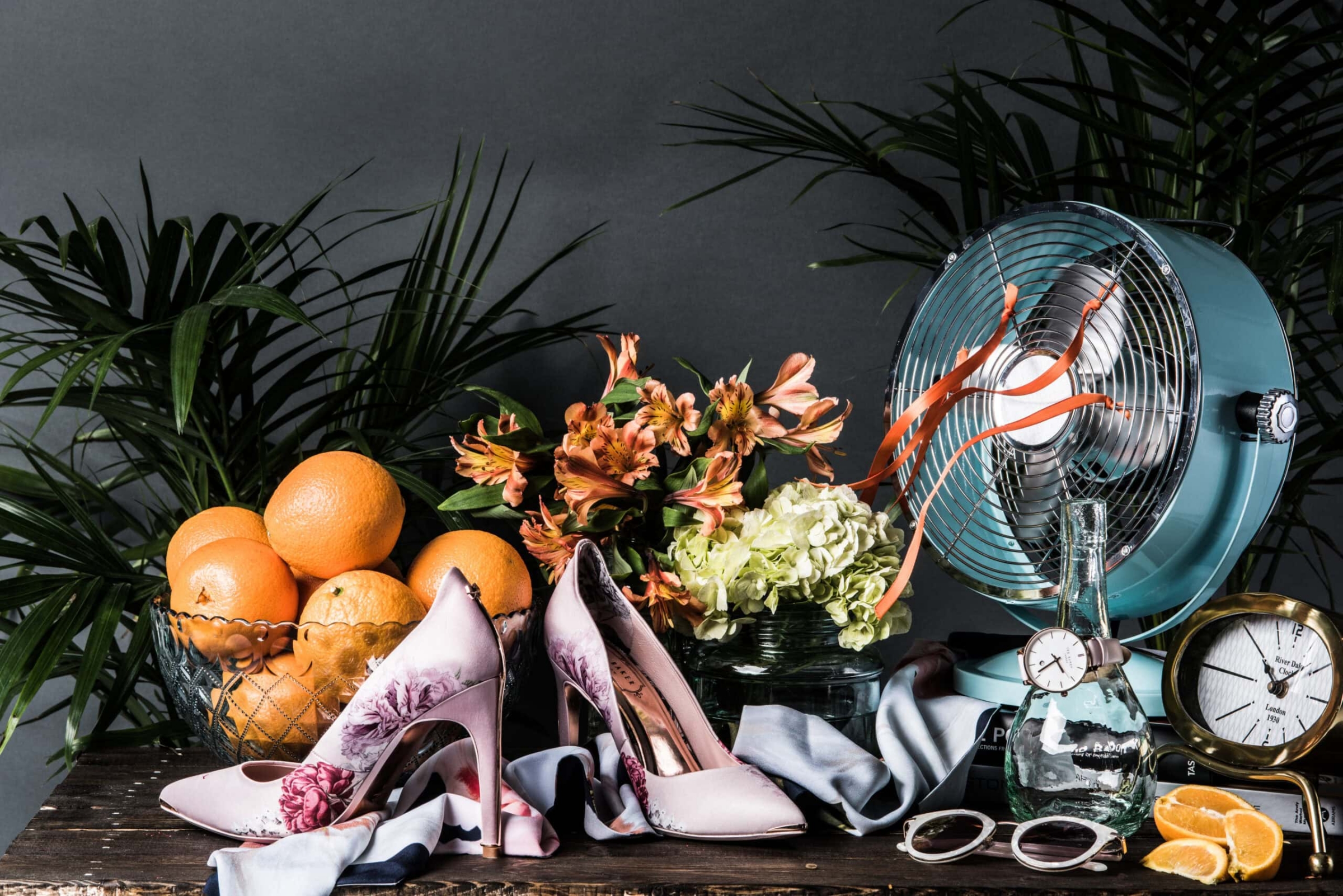 Ted Baker floral heels styled with oranges, flowers, and vintage fan, commercial photography Dallas, Texas