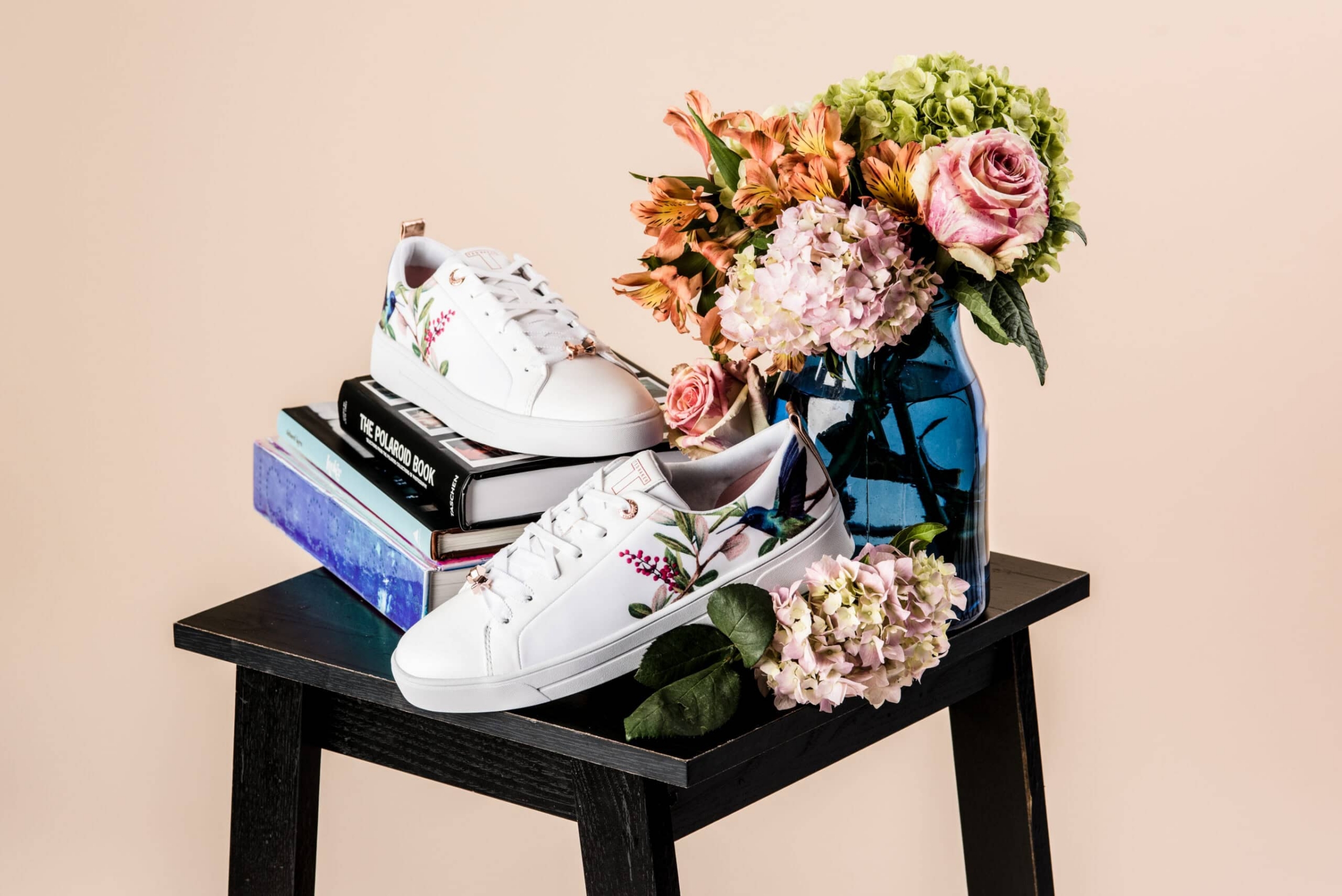 Ted Baker floral sneakers styled with flowers and books, commercial product photography in Dallas, Texas by David Loi Studios